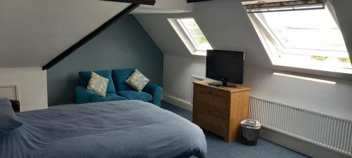 a bedroom with a bed and a tv and a chair at Ty Castell Guest House in Caerphilly