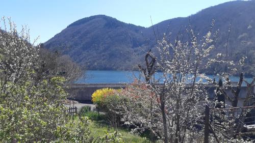 un pont sur une étendue d'eau avec une montagne dans l'établissement Maison de caractère, à Viala-du-Tarn