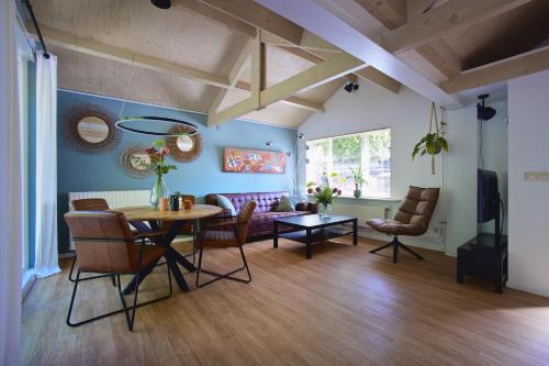 a living room with a table and chairs and a couch at Zandrijk in Egmond aan den Hoef