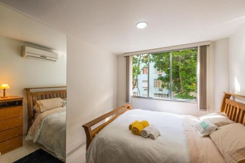 1 dormitorio con 2 camas y ventana en Loft no Posto Seis, Copacabana, en Río de Janeiro