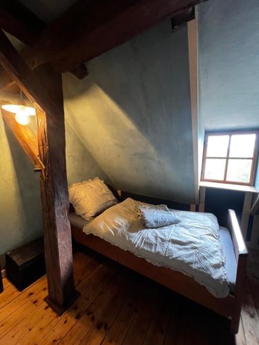 ein kleines Bett in einem Zimmer mit Fenster in der Unterkunft Banícka chalupa U felčiara in Banská Bystrica