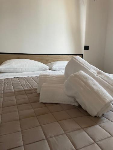 un letto bianco con lenzuola e cuscini bianchi di Residenza Rosy a Pescantina