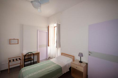 een slaapkamer met een bed, een bureau en een raam bij Hotel Villa Cecilia in Ischia