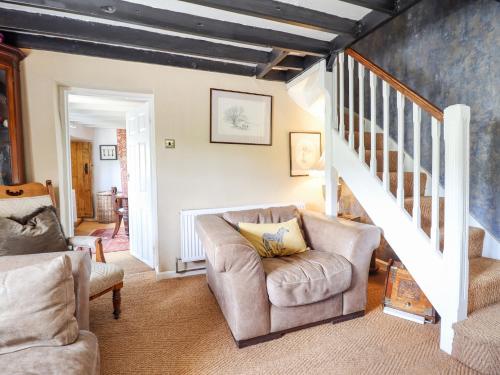 a living room with two chairs and a staircase at Neuadd Wen in Derwen