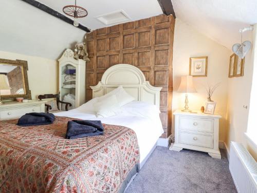 a bedroom with a large white bed with a wooden headboard at Neuadd Wen in Derwen