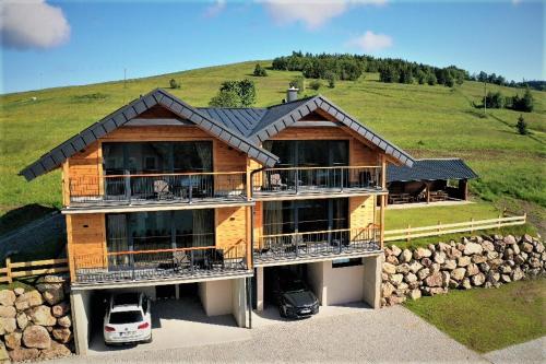 a house with a car parked in front of it at Chalets Belianky - WELLNESS in Ždiar