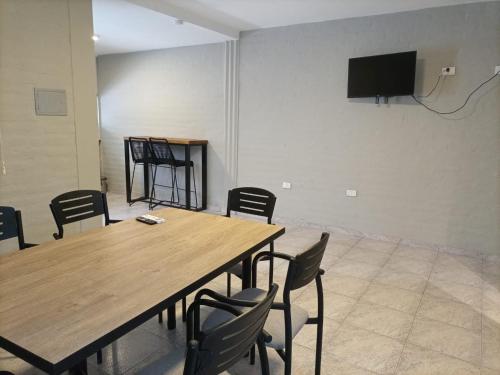 een kamer met een tafel en stoelen en een flatscreen-tv bij Apart America in Santa Lucía