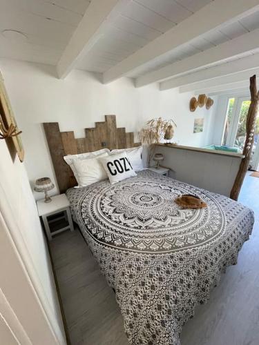 a bedroom with a bed with a cat laying on it at Meerpaal 43 Bergen in Bergen
