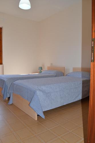 a bedroom with a large bed with a blue blanket at La Limonaia in Marciana Marina