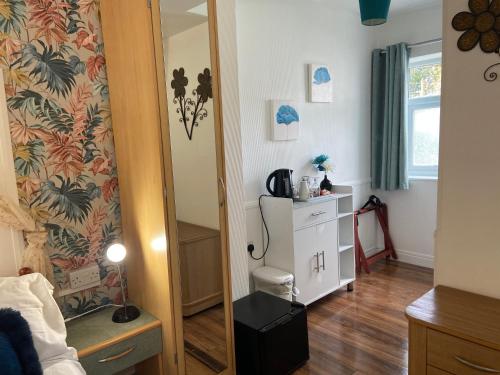 a bedroom with a mirror and a dresser in it at Aquarius B&B in Newquay