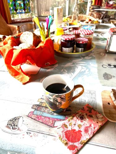 a cup of coffee and a plate of food on a table at 2 CHAMBRES B&B PRÈS DE L'AÉROPORT ET DU MEETT in Blagnac