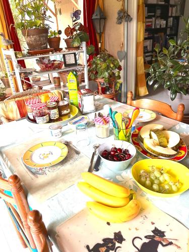 a table with bananas and other fruits on it at 2 CHAMBRES B&B PRÈS DE L'AÉROPORT ET DU MEETT in Blagnac