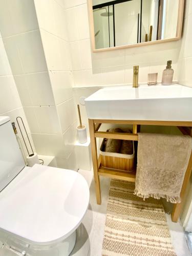 une salle de bain avec des toilettes blanches et un lavabo dans l'établissement SeaYou, à Wimereux