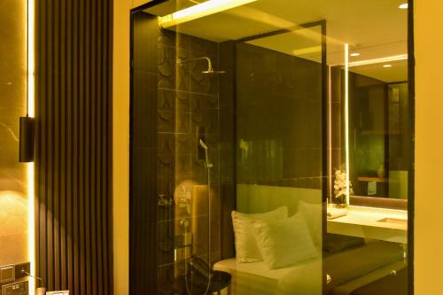 a bathroom with a shower with a bed and a mirror at Vertigo Hotel in Lagos