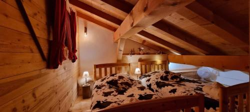 a bedroom with a bed in a room with wooden ceilings at SUPERBE DEMI CHALET LUXUEUX 120M² 8 Personnes à SALLANCHES. in Sallanches