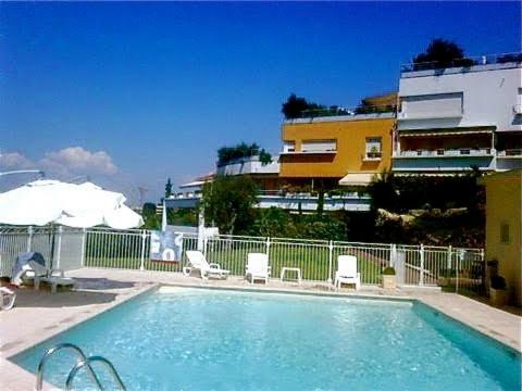 une piscine avec des chaises longues et un bâtiment dans l'établissement PARC DE DIANE, à Antibes