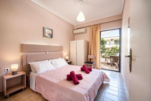 Un dormitorio con una cama con almohadas rojas. en Prestige Holiday Apartments, en Cos
