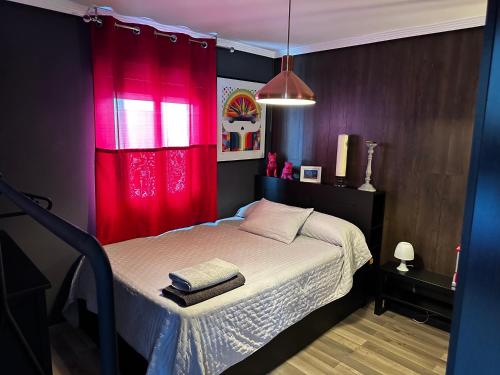 a bedroom with a bed with a red curtain at KB HOME Puertollano in Puertollano