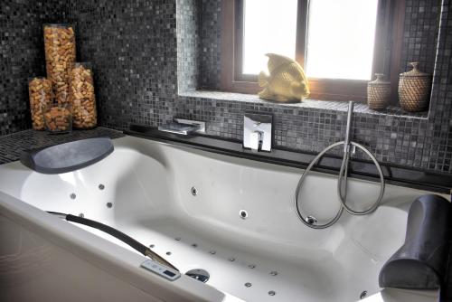 a white bath tub in a bathroom with a window at Home Apartments Jerez in Jerez de la Frontera