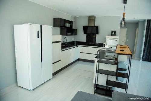 une cuisine avec un réfrigérateur et une table à l'intérieur dans l'établissement Villa Honoré bord mer/ jacuzzi, au Grau-dʼAgde