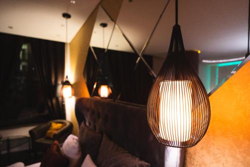 a living room with a couch and a large light fixture at Apartments with jaccuzi in Vilnius