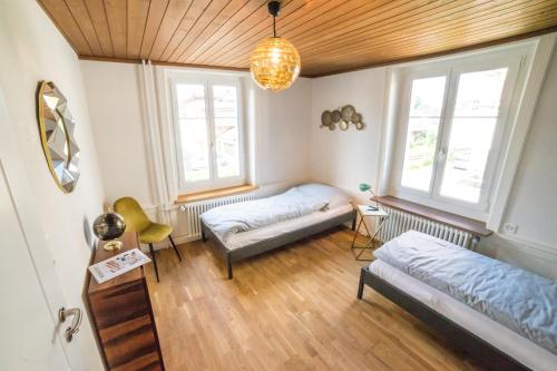 a bedroom with two beds and two windows at Tilia Apartments in Uster
