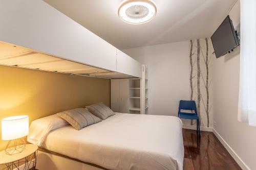 a small bedroom with a bed and a tv at Victorooms in Bilbao