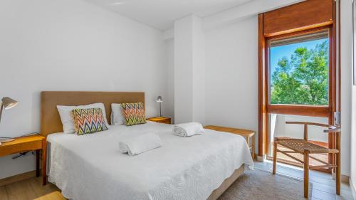 a bedroom with a white bed and a window at Casa Meri in Alvor