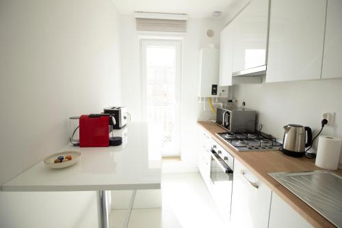 uma cozinha com armários brancos e um balcão branco em 2 Rooms A504 StayInn by Cosmopolis em Ştefăneştii de Jos