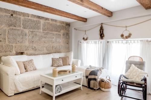 sala de estar con sofá blanco y pared de ladrillo en Casa MIMOSA Vigo, en Vigo