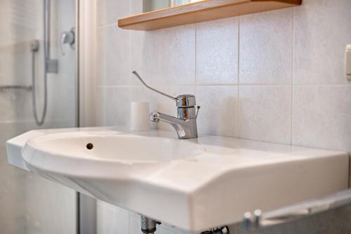 a white sink in a bathroom with a shower at Lindenhof Apt 9 in Vandoies