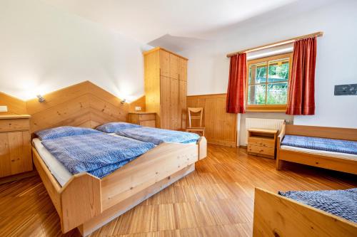 1 dormitorio con 2 camas, escritorio y ventana en Lindenhof Apt 9, en Vandoies
