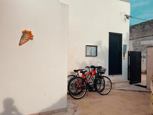 B&B Borgo Monacizzo في Monacizzo: دراجتين متوقفتين بجانب جدار مع فراشة على الحائط