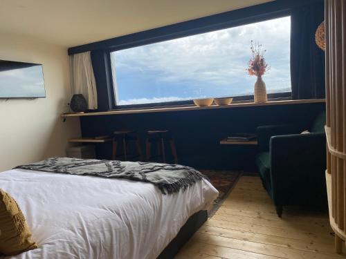 a bedroom with a bed and a large window at LUZZ me - Casa das Doze Ribeiras in Doze Ribeiras