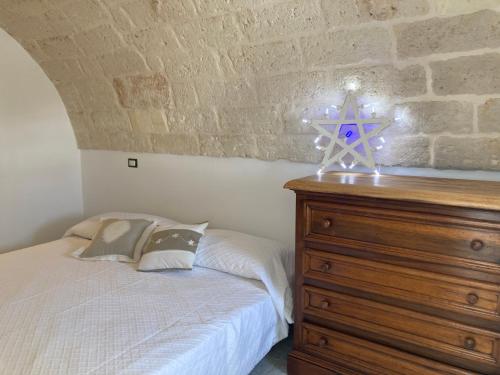 een slaapkamer met een bed en een houten dressoir bij Dimora le Picciose in Ostuni