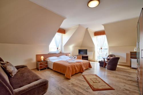a bedroom with a bed and a couch at VILLA DAIRA in Ustronie Morskie