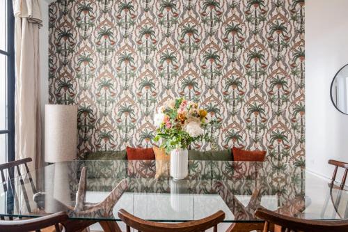 a dining room with a table with a floral wallpaper at Wonderful flat in the Marais neighbourhood - Paris - Welk in Paris