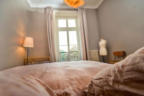 une chambre avec un grand lit et une fenêtre dans l'établissement S8 Grimaldi Suite Centrale 5min de la Mer AC, à Nice