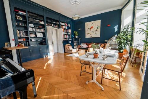 un salon avec une table et un piano dans l'établissement S8 Grimaldi Suite Centrale 5min de la Mer AC, à Nice