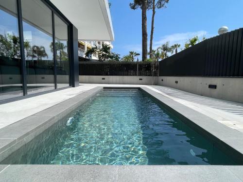 a swimming pool in front of a house at Rentalmar Suites Salou Families Only in Salou