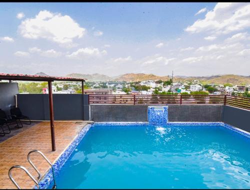 a swimming pool on the roof of a building at Hotel Dosa plaza in Udaipur