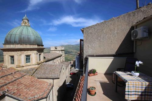 a balcony with tables and a building with a dome at Al Centro in Gangi