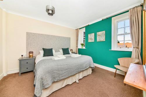 a bedroom with a bed and a green wall at Finest Retreats - Pennine Hall Apt in Thirsk