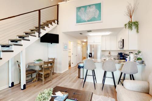 a living room and kitchen with a staircase in a house at Grand Caribbean #425 in Orange Beach