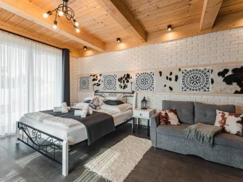 - une chambre avec un grand lit et un canapé dans l'établissement SASÓWKA APARTAMENT, à Maniowy