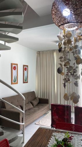 ein Wohnzimmer mit einem Sofa und einem Kronleuchter in der Unterkunft Mandakaru Residence Flat da Isa 01 in Porto De Galinhas