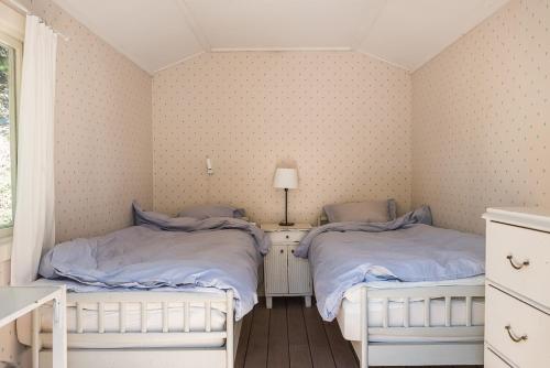 two twin beds in a room with a window at Fishermans cabin in Myttinge
