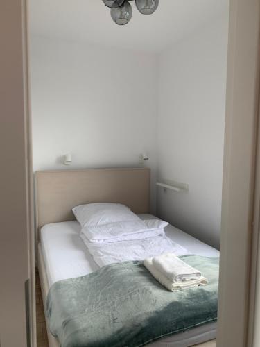 a white bed with a towel on top of it at Forest Apart III in Warsaw