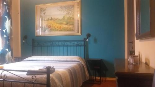 um quarto com uma cama com um quadro na parede em Mosci's Bed & Breakfast em San Damiano dʼAsti