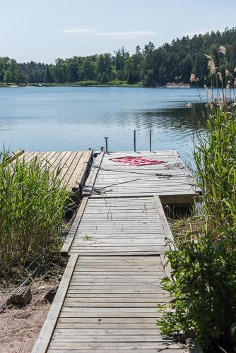 a wooden dock in the middle of a lake at Fishermans cabin in Myttinge